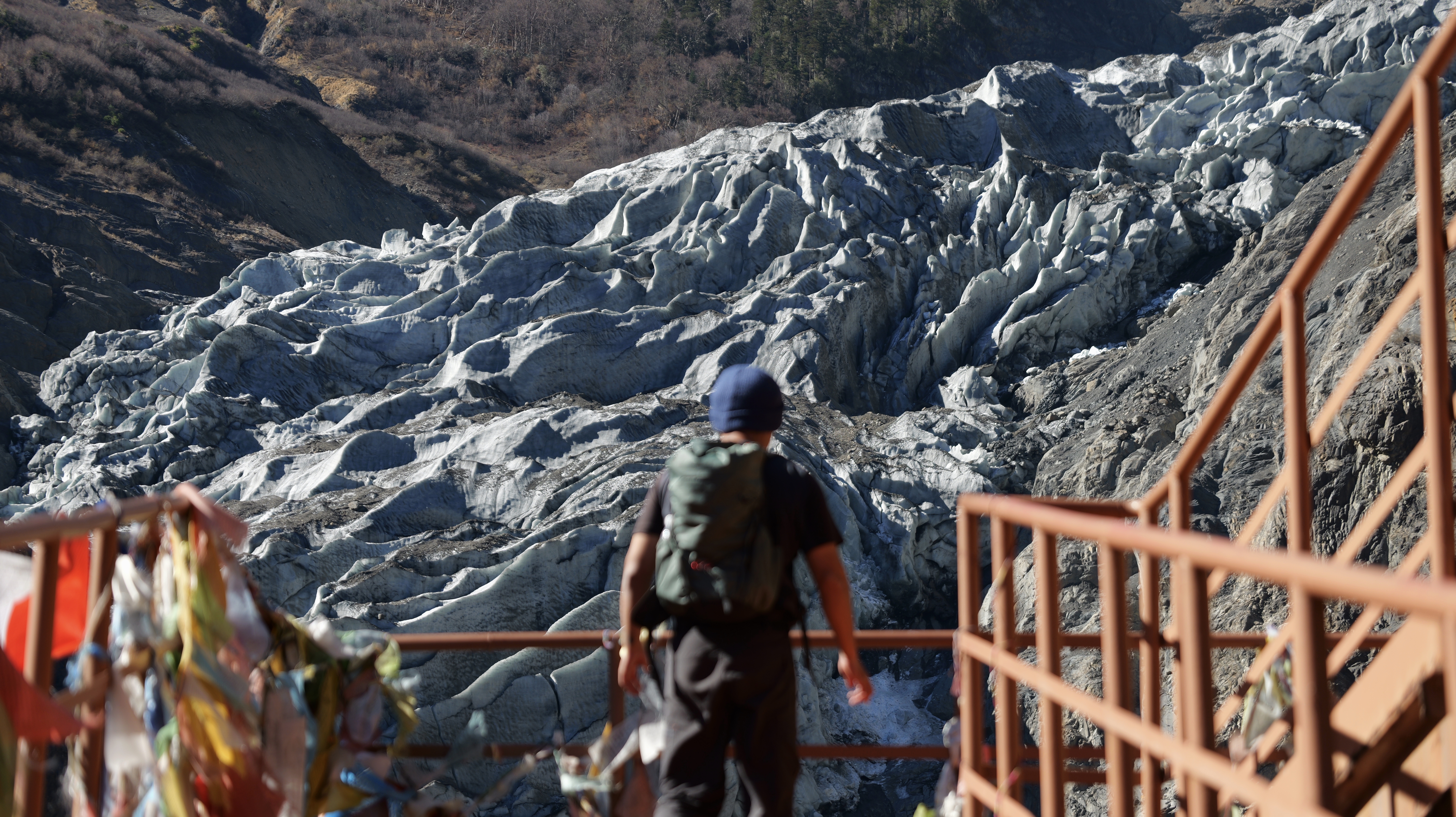 A hiker looking across a glacier in Yunnan